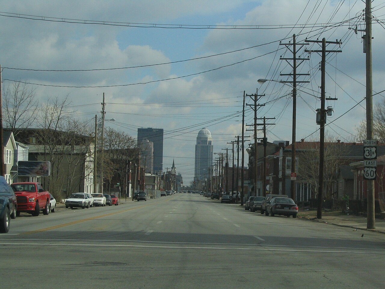 Avenida de Louisville, Kentucky, con vehículos estacionados y el downtown al fondo