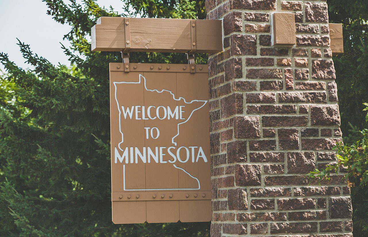 Letrero Welcome to Minnesota en la frontera estatal, estado donde tramitamos placas temporales